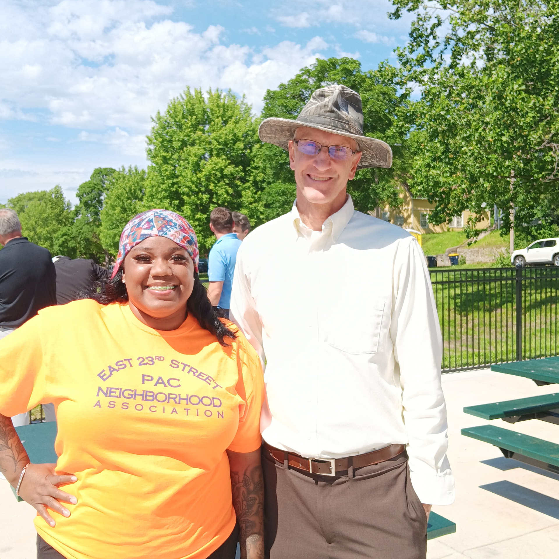 Sharlonda Riley in an East 23rd Street PAC Neighborhood Association shirt with a community member at a neighborhood event.